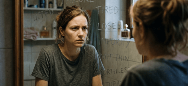 Person facing mirror with critical words reflection